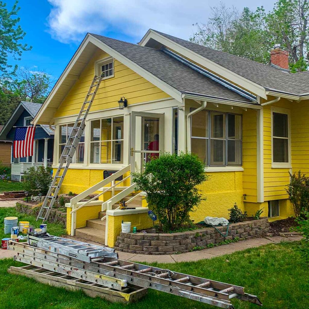 Exterior of home painted bright yellow with white trim
